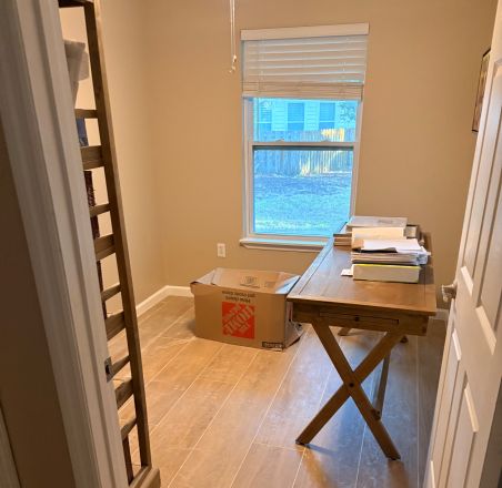 A room under renovation featuring windows and construction tools.